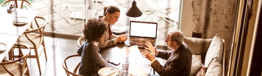 Three people meeting around a table